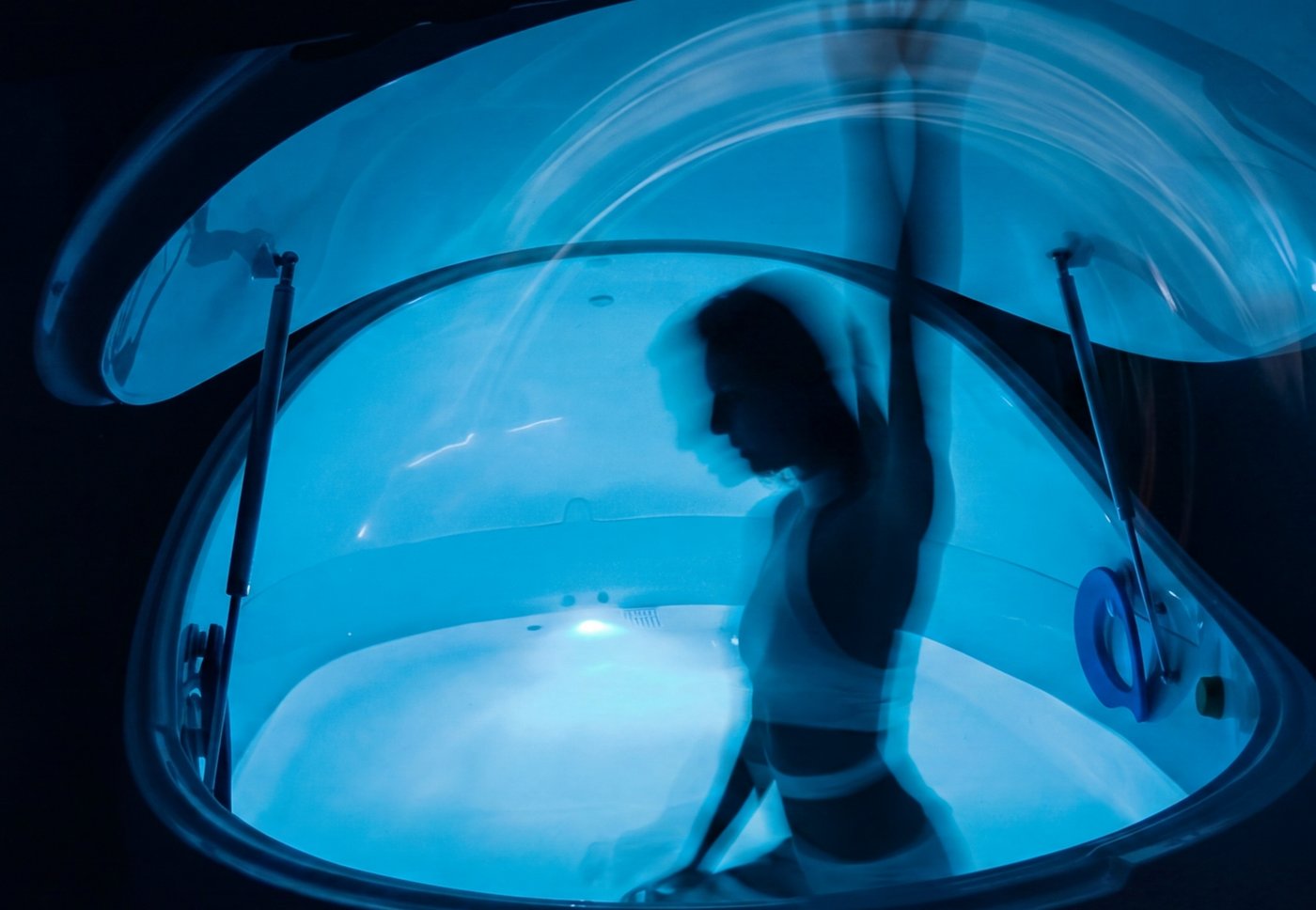 Person floating weightlessly in salt water in a float tank